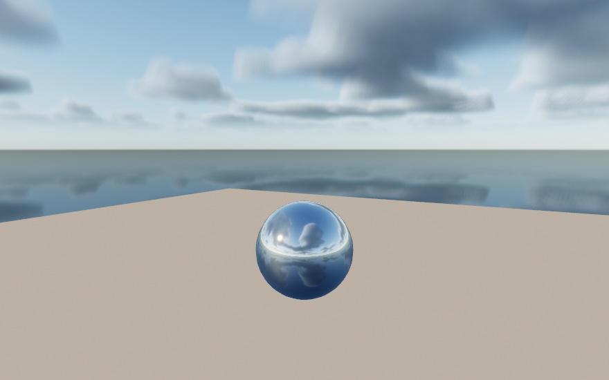 A chrome ball on a matte plain under a scattered cloud deck: solid white cumulus with shadowed undersides over real blue, the same deck reflected in the ball