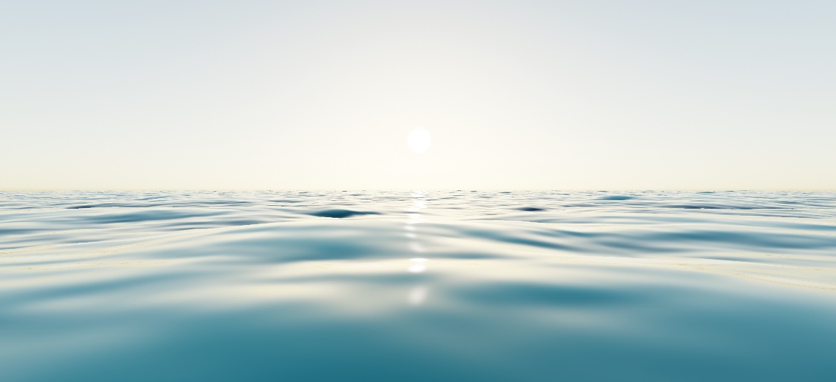 Open sea seen from just above the surface under a low sun: waves of several sizes crossing each other, teal in the troughs and pale where the sky catches a crest, with a soft column of light running from the sun down to the foreground